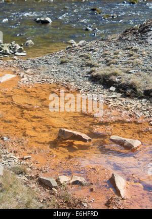 Verunreinigtes Wasser fließt aus Stream von verlassenen Blei-Mine in Fluss mit sauberem Wasser Cwmystwyth Mid Wales UK verschmutzt Stockfoto