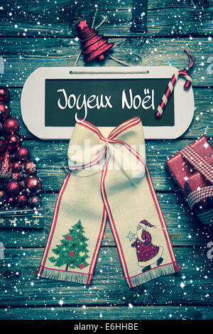 Frohe Weihnachten Grusskarte mit französischer Text auf hölzernen Hintergrund in rustikale shabby Stil. Stockfoto