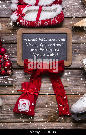 Frohe Weihnachtsgrußkarte in rot und weiß mit Holz und deutscher Text. Stockfoto