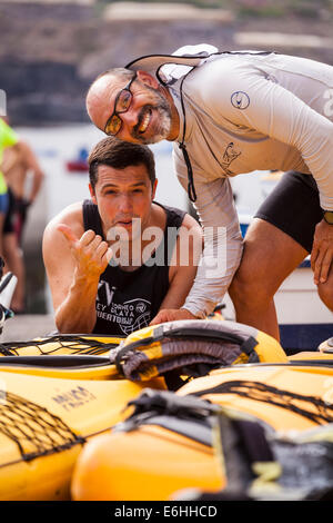 Zwei Athleten genießen einige Geplänkel für ein Kajak-Rennen vorbereiten von Playa San Juan, Teneriffa, Kanarische Inseln, Spanien. Stockfoto