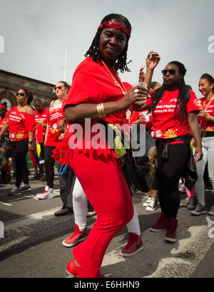 London, UK. 24. August 2014. Eine Dame in rot schüttelt ihr Zeug auf 2014 Notting Hill Carnival Credit: auf Anblick Photographic/Alamy Live News Stockfoto