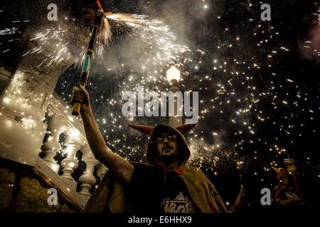 Sitges, Spanien. 23. August 2014. Ein Mitglied der "Ball de Diables" begibt sich seine Feuerwerkskörper während der nächtlichen "Correfoc" für die "Festa Major de Sitges" © Matthias Oesterle/ZUMA Wire/ZUMAPRESS.com/Alamy Live News Stockfoto