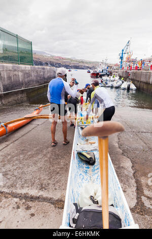 Sechs Mann Ruderteam startet ein Auslegerkanu am Playa San Juan, Teneriffa, Kanarische Inseln, Spanien. Stockfoto