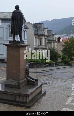 Eine Statue (von Henrick Ibsen oder Edward Grieg?) schaut aus dem Nationaltheater an einem regnerischen Tag in Bergen. Stockfoto