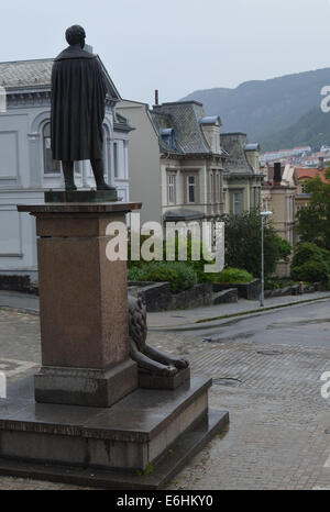 Eine Statue (von Henrik Ibsen oder Edward Grieg?) schaut aus dem Nationaltheater an einem regnerischen Tag in Bergen. Stockfoto