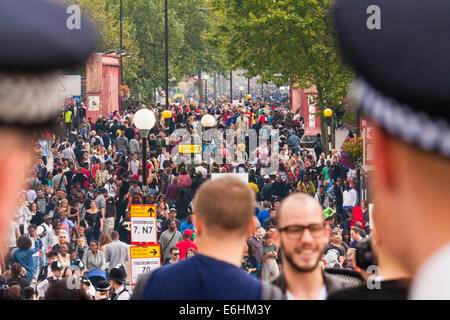 London, UK. 24. August 2014. Polizei ein Auge auf die wimmelnden Ladbroke Grove als Tausende von Londonern aller Rassen und Kulturen besuchen Notting Hill Carnival 'Familienfreundlich' Tag vor dem wichtigsten Karneval am August Bank Holiday Montag. Bildnachweis: Paul Davey/Alamy Live-Nachrichten Stockfoto