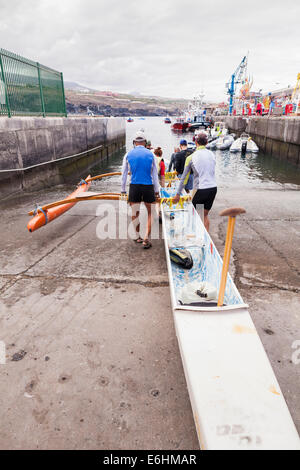 Sechs Mann Ruderteam startet ein Auslegerkanu am Playa San Juan, Teneriffa, Kanarische Inseln, Spanien. Stockfoto