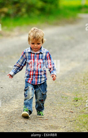 Ein kleiner Junge einen Kiesweg hinunter Stockfoto