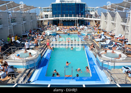 An Bord der Ruise-Schiff-Swimmingpools Jacuzzi-Einrichtungen, Leute entspannen sich auf überfüllten, beliebten Sonnenliegen, Sonnendeck, mediterrane Kreuzfahrt Stockfoto