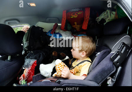 Ein kleiner Junge in einem sehr vollen Auto am Tag, den wir umgezogen Stockfoto