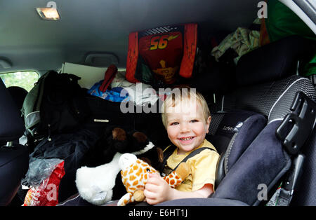 Ein kleiner Junge in einem sehr vollen Auto am Tag, den wir umgezogen Stockfoto