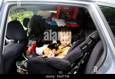 Ein kleiner Junge in einem sehr vollen Auto am Tag, den wir umgezogen Stockfoto