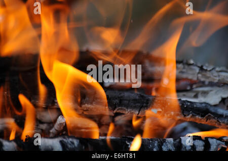 roten Feuerzungen auf hölzernen Maschinenbordbüchern Stockfoto