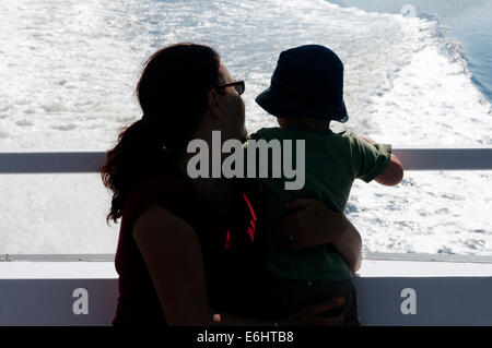 Mutter und Sohn Silhouette gegen den Anschluss an ein Boot an einem Sommer-Kreuzfahrt Stockfoto