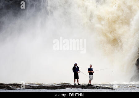 Zwei wilde Fischern, die mit dem Chute De La Chaudiere Wasserfall donnernd hinter ihnen in Quebec Kanada Stockfoto