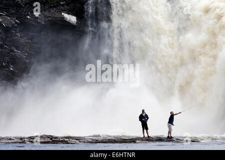 Zwei wilde Fischern, die mit dem Chute De La Chaudiere Wasserfall donnernd hinter ihnen in Quebec Kanada Stockfoto