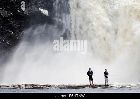 Zwei wilde Fischern, die mit dem Chute De La Chaudiere Wasserfall donnernd hinter ihnen in Quebec Kanada Stockfoto