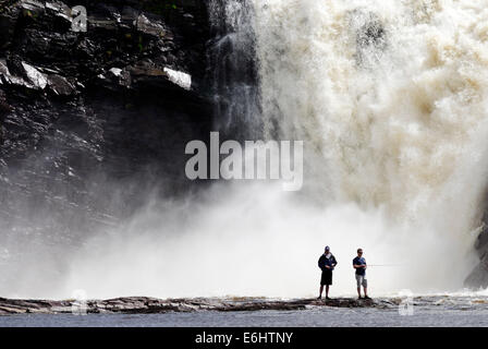 Zwei wilde Fischern, die mit dem Chute De La Chaudiere Wasserfall donnernd hinter ihnen in Quebec Kanada Stockfoto