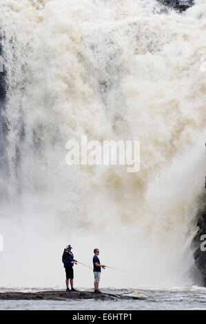 Zwei wilde Fischern, die mit dem Chute De La Chaudiere Wasserfall donnernd hinter ihnen in Quebec Kanada Stockfoto