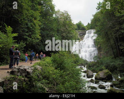 Touristen, die die großen Wasserfälle bei Cascades de Herisson im Jura in Frankreich Stockfoto