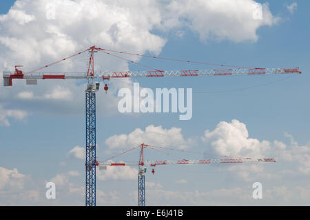 zwei hohe Kräne auf blau bewölktem Himmelshintergrund Stockfoto