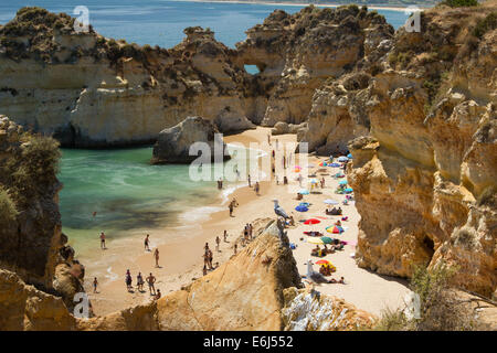 Menschen genießen einen sonnigen Tag am Strand von Alvor Portugal, ist der Strand von Sandstein-Klippen geschützt. Stockfoto