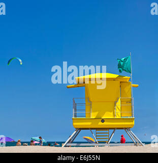 Gelb Life Guard Tower am Strand mit Leuten, kite-Surfer und blauer Himmel. Stockfoto