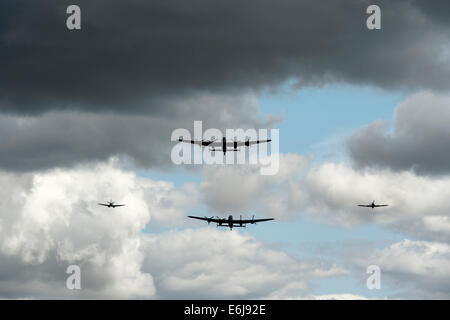 Lancaster-Bomber und Spitfire Flugzeuge fliegen Vergangenheit gegen stürmischen Regenwolken an militärischen Odyssey zeigen, Detling, Kent, England Stockfoto
