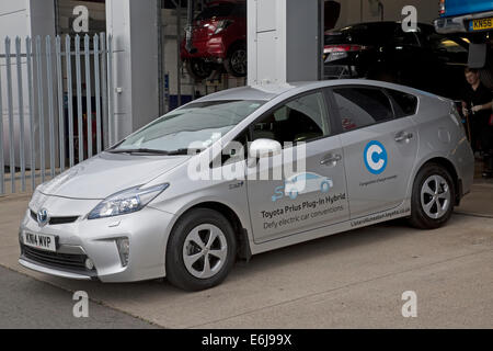 Toyota Prius Plug In OLEV ultra low Emission Mittelklasse-Plug-in Hybrid-Elektro-Fahrzeug geparkt außerhalb Lister Garage Stockfoto