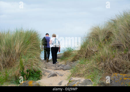 Ein Mann und eine Frau spazieren am Strand. Stockfoto