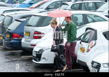 Swansea, Großbritannien. 25. August 2014. Wetter: Ein paar Fuß durch einen gepackten Einzelhandel-Parkplatz - Menschen entscheiden, auf einem sehr nassen Bank Holiday Montag Einkaufen in Wales. Bildnachweis: Graham M. Lawrence/Alamy Live-Nachrichten. Stockfoto