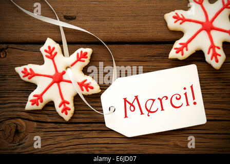 Star-Weihnachtsplätzchen mit roten und weißen Dekoration und ein Label auf dem französischen Wörter Merci geschrieben ist, das bedeutet Dank Stockfoto