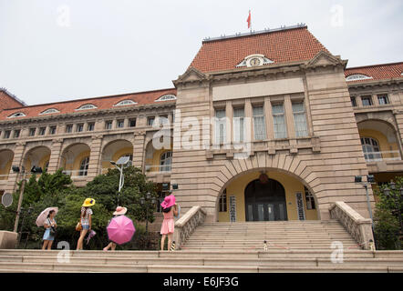 Touristen stehen vor Gebäude der colognial-Ära, das ehemalige Hauptquartier der deutschen colognial Verwaltung in China in Qingdao, China, 16. August 2014.  Qingdao war die einzige deutsche Kolonie im Fernen Osten. Mit dem Beginn des ersten Weltkrieges im Jahre 1914 wurde die Stadt von Japan übernommen. Heute unterhält Qingdao, einer Stadt mit Millionen von Einwohnern, jedoch noch einige Spuren der deutschen Kolonialzeit. Foto: Friso Gentsch/dpa Stockfoto