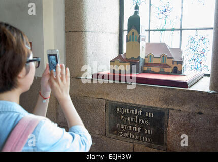 Qingdao, China. 16. August 2014. Ein Besucher wird ein Foto eines Modells der deutschen protestantischen "Christuskirche" (Church of Christ) in China in Qingdao, China, 16. August 2014. Qingdao war die einzige deutsche Kolonie im Fernen Osten. Mit dem Beginn des ersten Weltkrieges im Jahre 1914 wurde die Stadt von Japan übernommen. Heute unterhält Qingdao, einer Stadt mit Millionen von Einwohnern, jedoch noch einige Spuren der deutschen Kolonialzeit. Foto: Friso Gentsch/Dpa/Alamy Live News Stockfoto