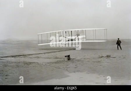 Wilbur Wright Uhren als Bruder Orville Wright Piloten der Wright Flyer während den ersten erfolgreichen nachhaltigen Motorflug 17. Dezember 1903 in Kill Devil Hills, North Carolina. Stockfoto