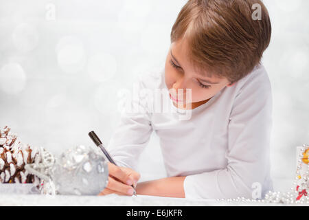 Junge schreibt einen Brief an den Weihnachtsmann. Stockfoto