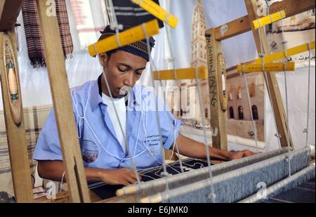 Sanaa, Jemen. 25. August 2014. Ein jemenitischer Mann webt Tuch im Ladengeschäft während der einwöchigen Sanaa Sommerfest in Sanaa, Jemen, am 25. August 2014. Jemen startete das 7. Sanaa-Sommerfest in der Hauptstadt Sanaa. Die Behörden wollen den Tourismus in dem arabischen Land zu erholen, die politischen Unruhen und tödliche Konflikte seit 2011 gesehen hat. Bildnachweis: Mohammed Mohammed/Xinhua/Alamy Live-Nachrichten Stockfoto