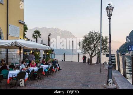 Restaurant an der Harbourfront bei Sonnenuntergang in der Altstadt, Riva del Garda, Gardasee, Trento, Italien Stockfoto