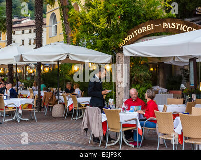 Restaurant am frühen Abend entlang der Hafenpromenade in der Altstadt, Riva del Garda, Gardasee, Trento, Italien Stockfoto