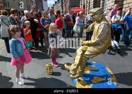 Zwei junge Mädchen starrte auf ein Straßenkünstler wie eine Statue offenbar defying Gravity, Edinburgh Fringe Festival, Edinburgh Stockfoto