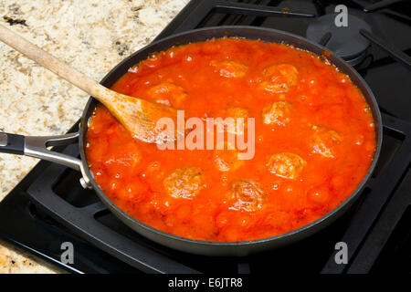 Spaghetti marinara Sauce mit leckeren Frikadellen vor dem Hinzufügen zu einem Haufen von Nudeln in einem Topf Sieden. Stockfoto