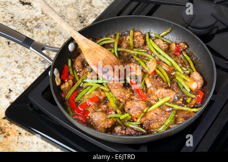 Frische asiatische Stil Rindfleisch unter Rühren braten mit grünen Bohnen, Paprika und Zwiebeln in einer Pfanne simmering. Stockfoto