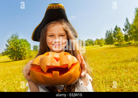 Halloween Mädchen im Kostüm Pirat hält Kürbis Stockfoto