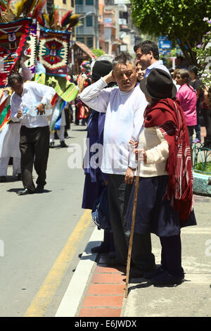 BANOS, ECUADOR - 2. März 2014: Unbekannte Leute reden auf den am Straßenrand Weile bewegt sich der traditionelle Karnevalsumzug auf Stockfoto