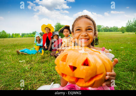 Glückliches afrikanisches Mädchen hält Halloween-Kürbis Stockfoto