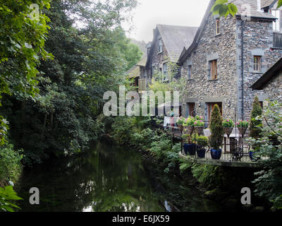 Traditionellen Steinhäusern entlang dem Fluß Rothay im Dorf von Grasmere, Seenplatte, Cumbria, England Stockfoto