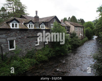 Traditionellen Steinhäusern entlang dem Fluß Rothay im Dorf von Grasmere, Seenplatte, Cumbria, England Stockfoto