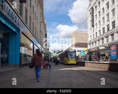 Eine Straßenbahn und Shopper an der Market Street im Stadtzentrum von Manchester, England Stockfoto