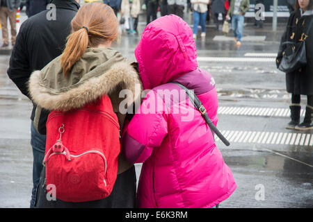 Blick von hinten auf Mädchen in Regenmäntel Stockfoto