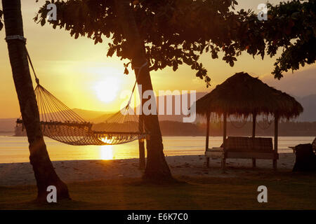Hängematte am Strand bei Sonnenaufgang, in der Nähe von Pemenang, Lombok, Indonesien Stockfoto